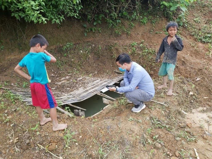 Một người lấy nước tại điểm thu nước ven sườn đất